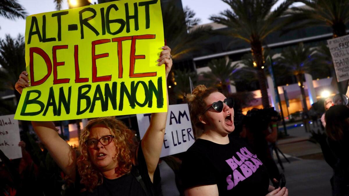 Michelle Fowle, left, and Sandra Vanderloh join a small group of protesters outside the Anaheim Marriott.