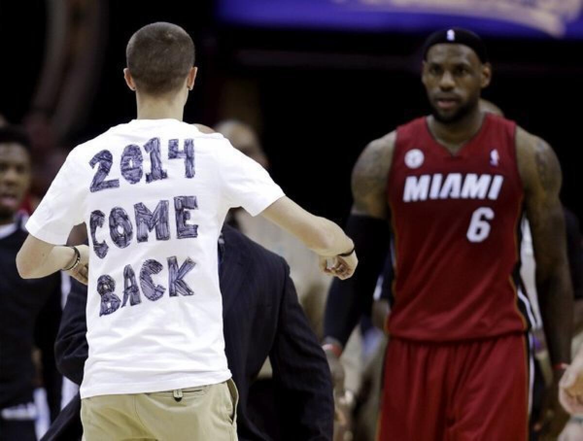 A fan runs onto the court during Wednesday's Heat-Cavs game to meet LeBron James and maybe get a message across.