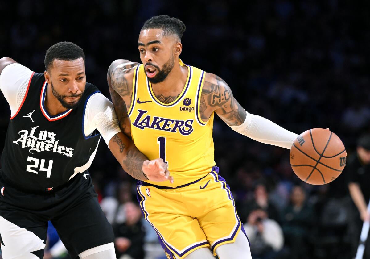Lakers guard D'Angelo Russell drives past Clippers guard Norman Powell.