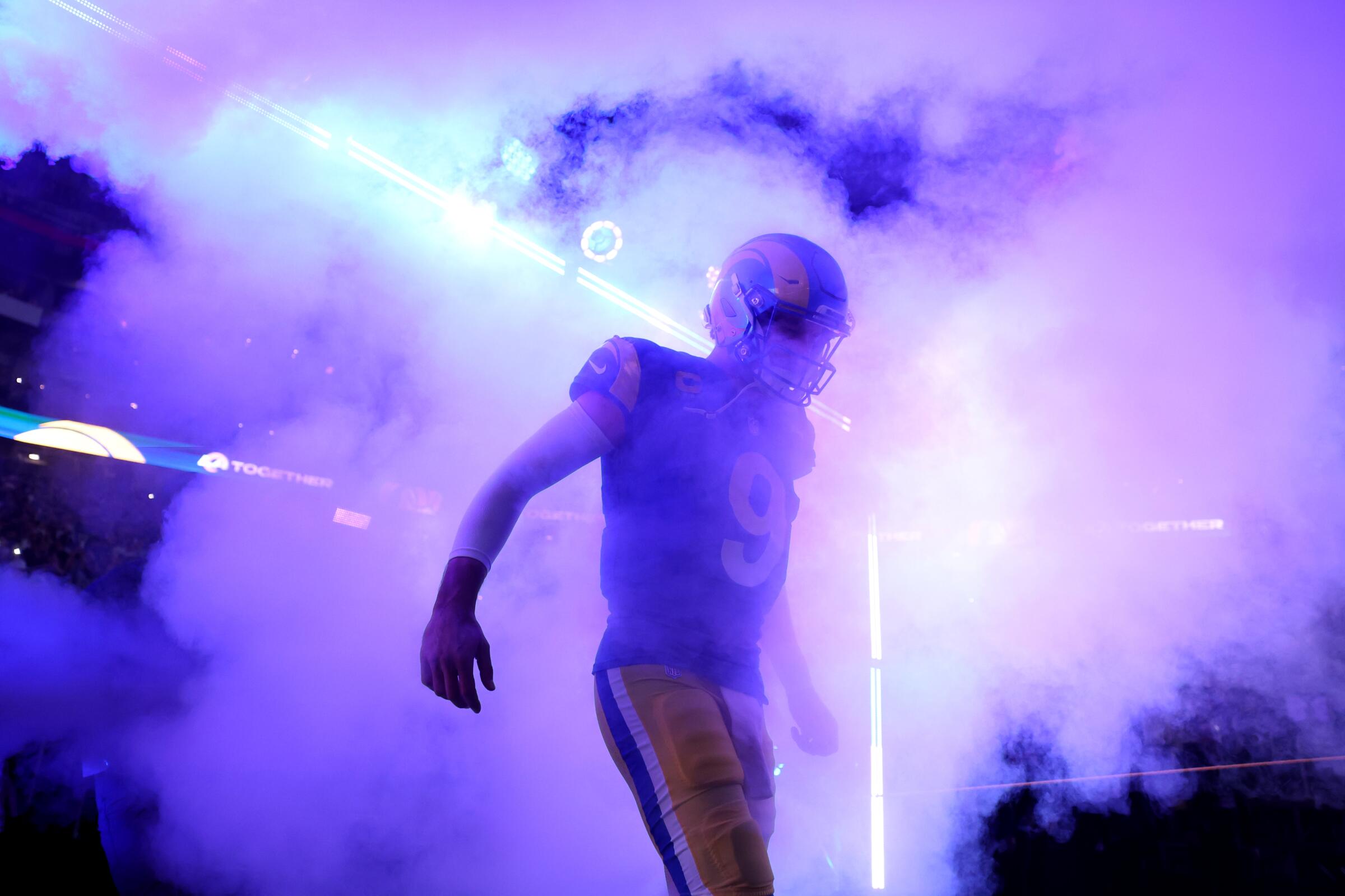Rams quarterback Matthew Stafford takes the field shrouded in smoke as he's introduced before a playoff game with the Vikings