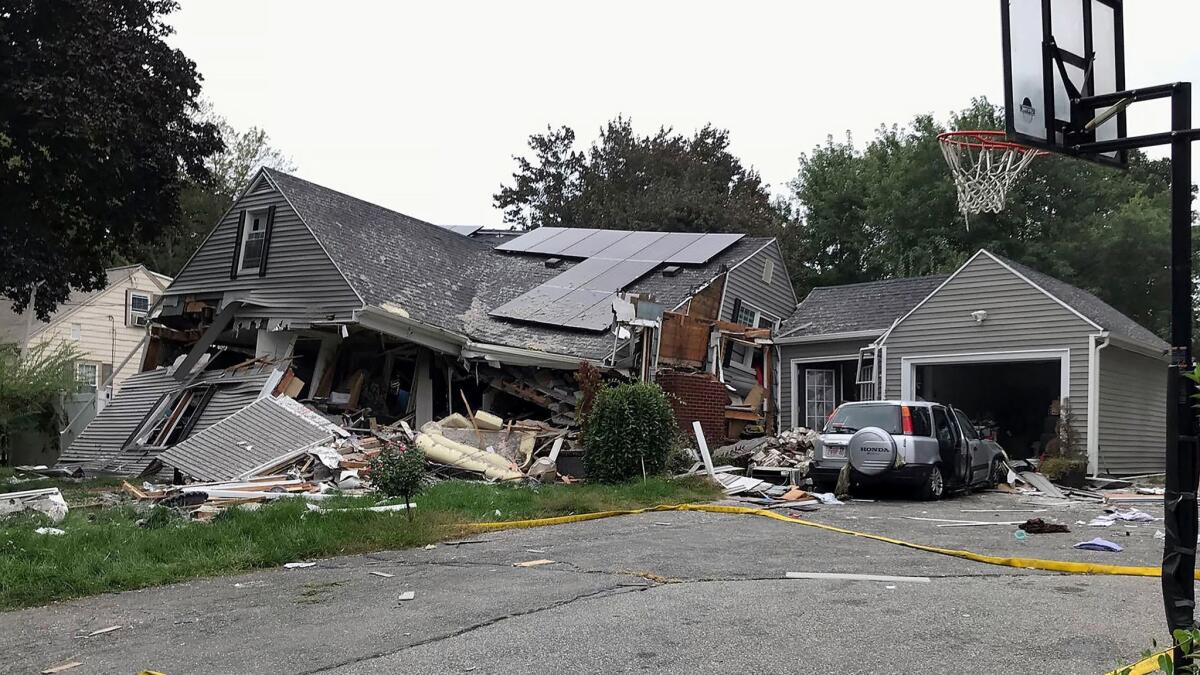 A collapsed home and car sit damaged Thursday in Lawrence, Mass., after a series of gas explosions in several communities north of Boston.