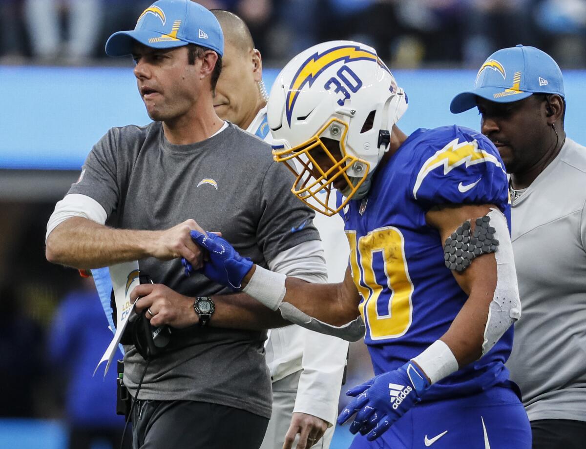 Chargers coach Brandon Staley shakes hands with running back Austin Ekeler.