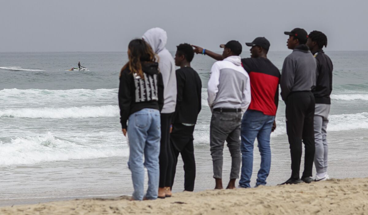 Family and friends watch as lifeguards searched for a drowning victim off of Mission Beach 