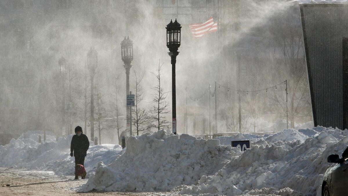 Wind-whipped snow swirls in Boston's Seaport district on Friday.