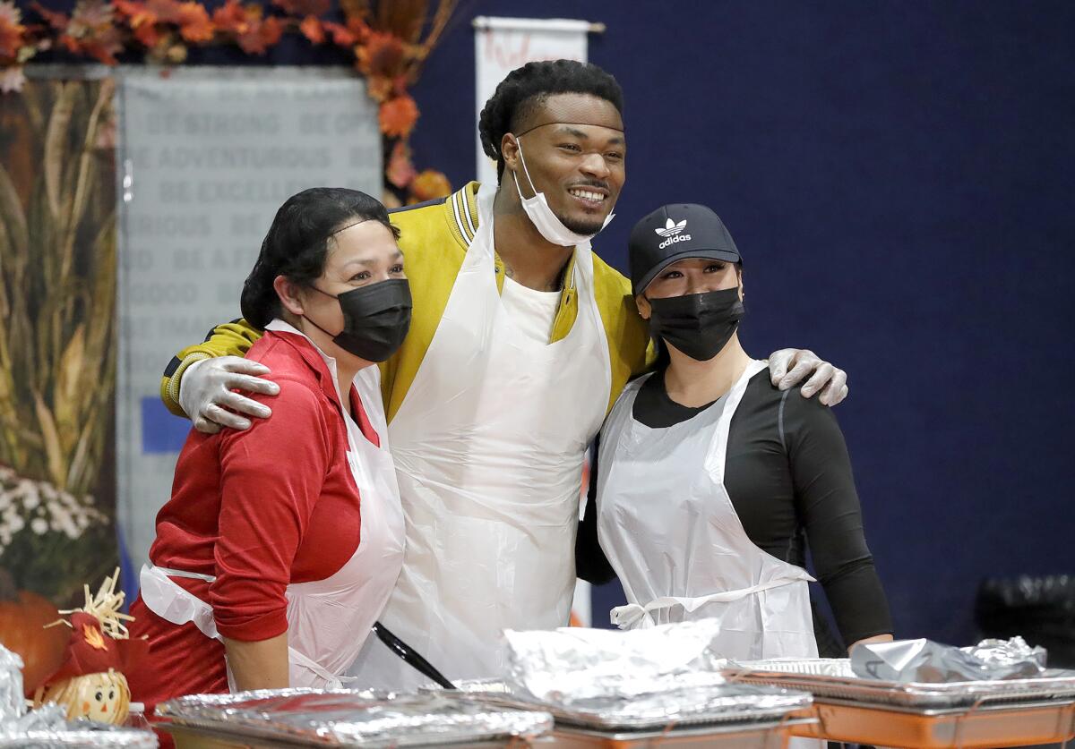 L.A. Chargers football star Derwin James joins fellow volunteers at a Thanksgiving dinner.