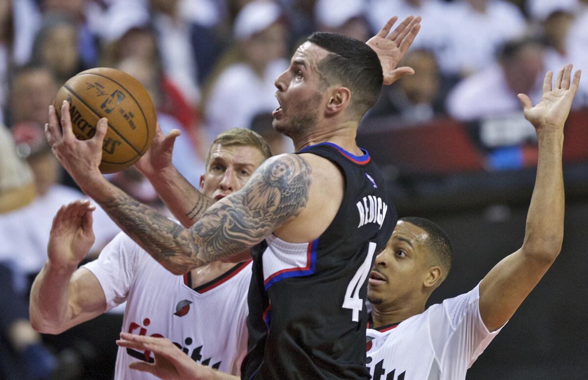 Clippers guard J.J. Redick, center, shoots in front of Portland Trail Blazers center Mason Plumlee, left, and guard C.J. McCollum, right, during the first half of Game 3 of the Western Conference playoff on Saturday.