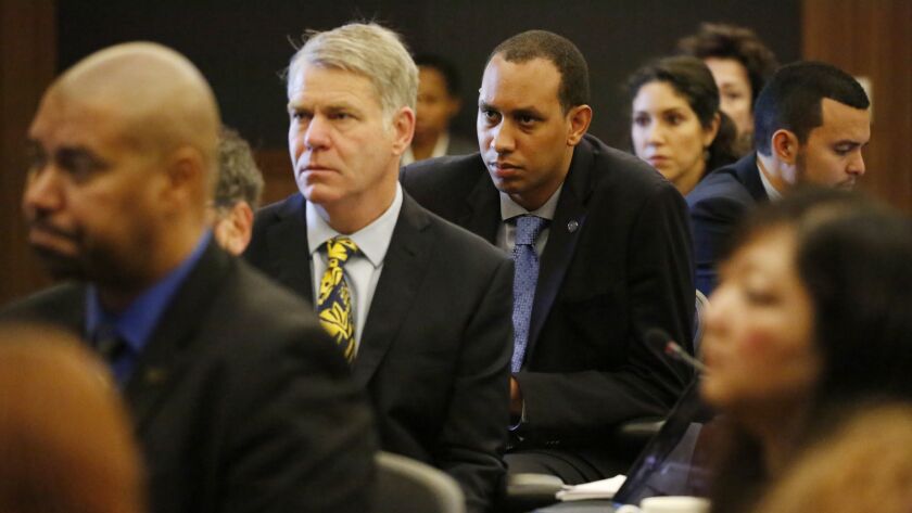 Devon Graves, center, student regent-designate, and members of the University of California Board of Regents listen to speakers protest a tuition increase for nonresident students in a meeting at UCLA.