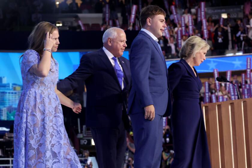 DNC CHICAGO, IL AUGUST 21, 2024 - Democratic vice presidential nominee Minnesota Gov. Tim Walz, second left, with daughter Hope, left, son Gus and wife Gwen, right, on the stage during the Democratic National Convention Wednesday, Aug. 21, 2024, in Chicago. (Robert Gauthier/Los Angeles Times)