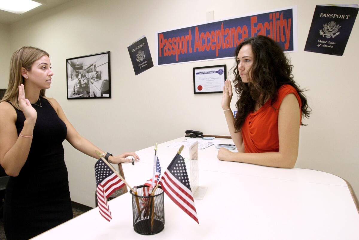 City of Burbank passport agent Megan Anghel, left, administers an oath to Burbank resident Anna Krestyn during the passport application process in this file photo taken on Oct. 8, 2015.