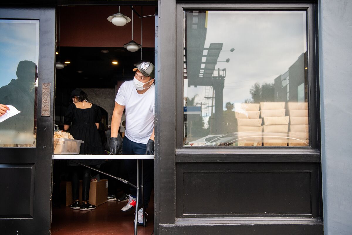 People line the block outside Chi Spacca as Nancy Silverton and her staff distribute 300 free meals, and other supplies, to those in the restaurant industry who have been affected by closures due to the coronavirus pandemic on Thursday, March 19, 2020.