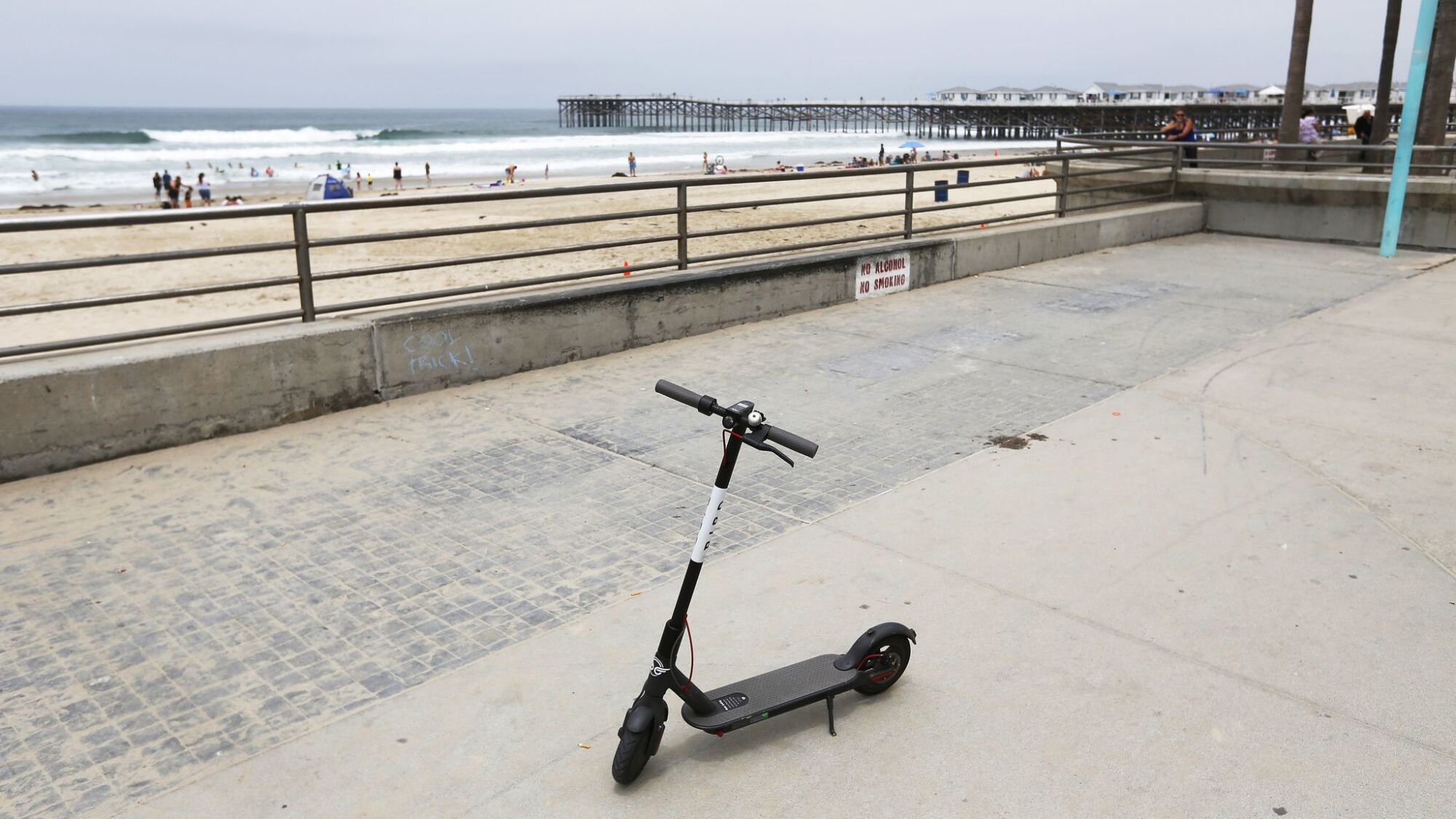 A Bird Scooter is parked on the boardwalk in Pacific Beach.