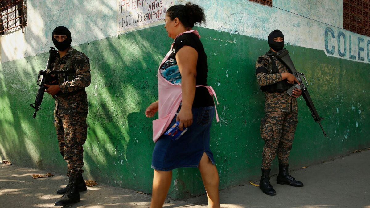 Soldiers patrol a San Salvador neighborhood where gang violence is prevalent.