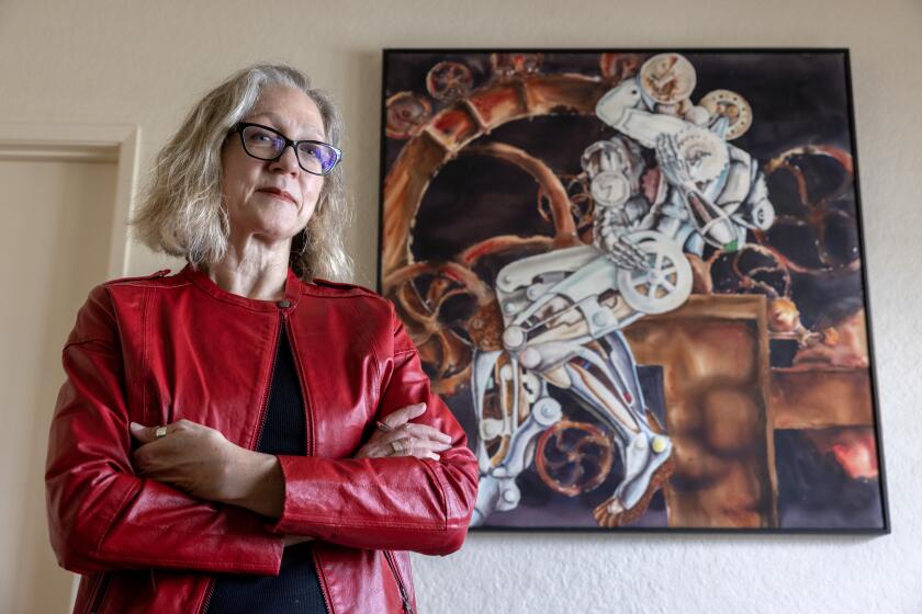 VISTA, CA - MARCH 14, 2024: Artist Krista Timberlake stands next to her painting, titled "Metal on Metal", at her home in Vista on Wednesday, March 14, 2024. (Hayne Palmour IV / For The San Diego Union-Tribune)