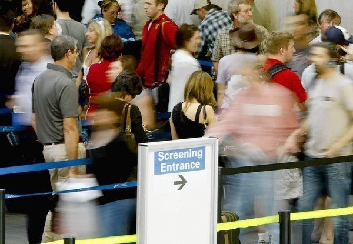 Passengers wait in line at a security checkpoint at Los Angeles International Airport.