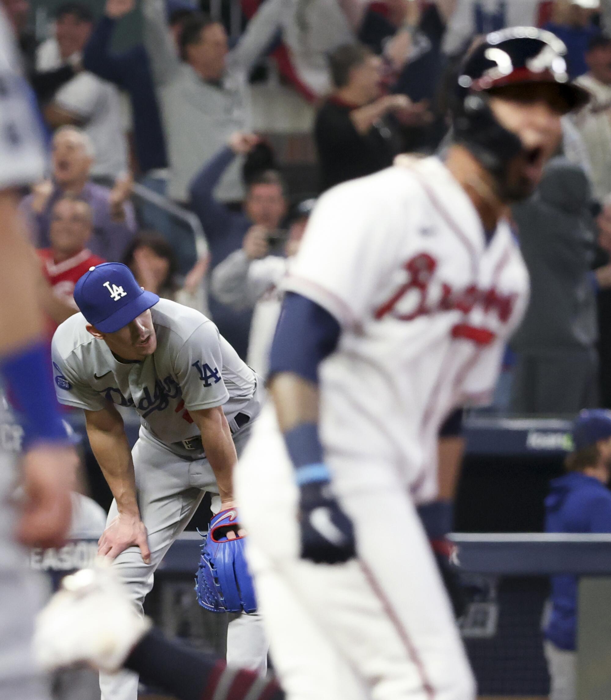 Walker Buehler reacts after allowing a three-run home run to Braves' Eddie Rosario.