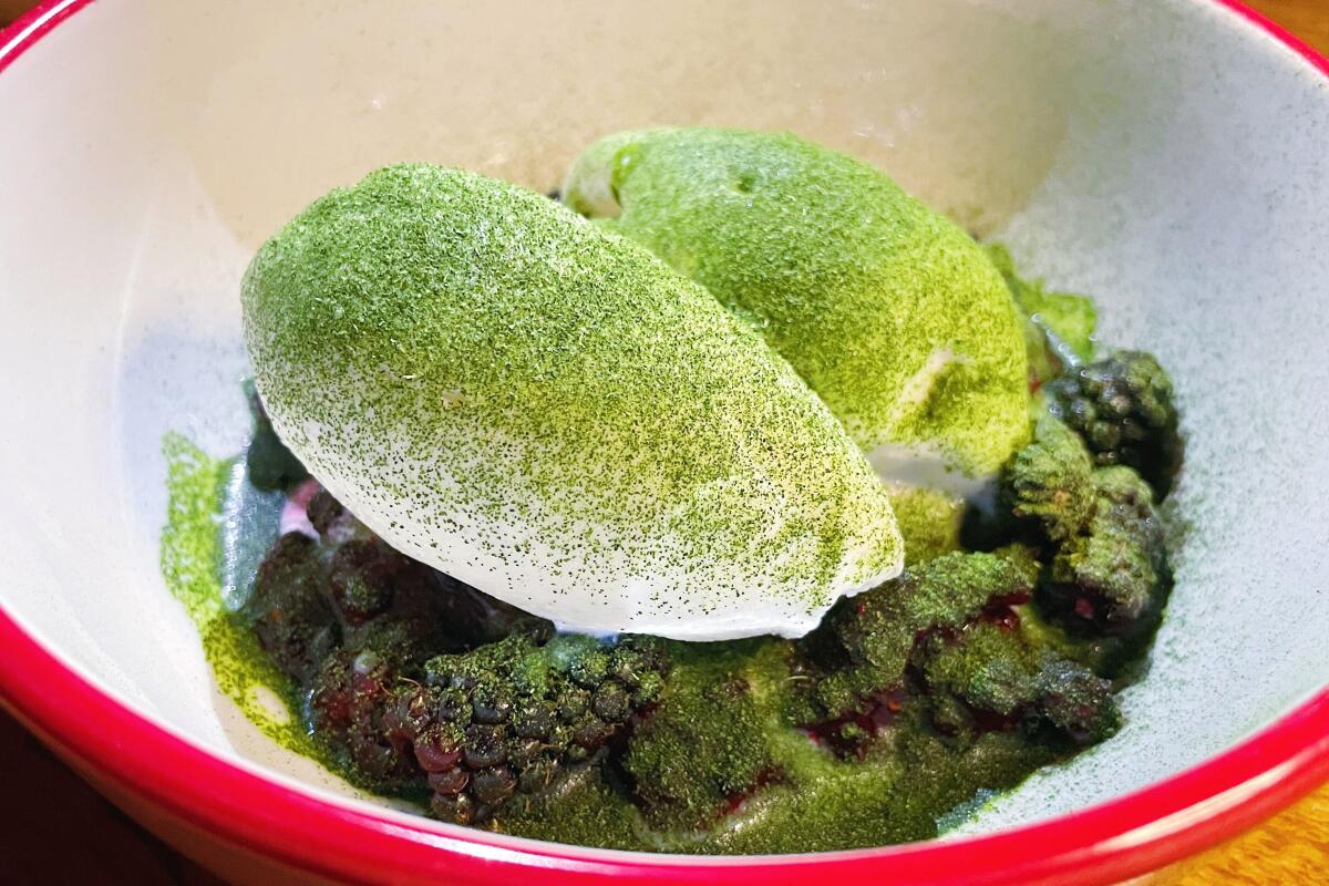 Two quenelles of burrata ice cream dusted with dehydrated herbs sit atop mulberries at Best Bet Pizzeria in Culver City