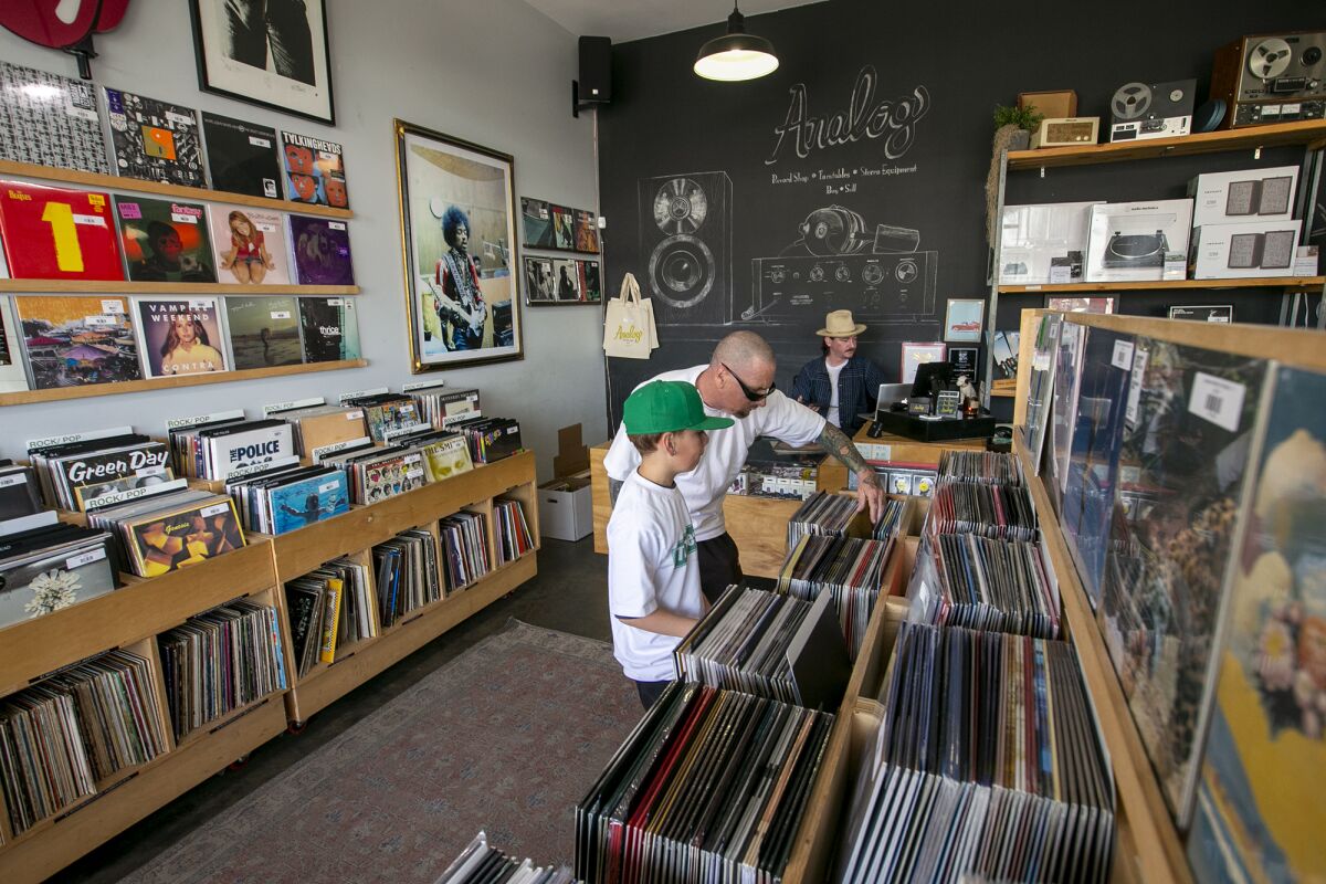Steve Dougherty and his son, Asaph, shop at Analog Record Shop in Orange.