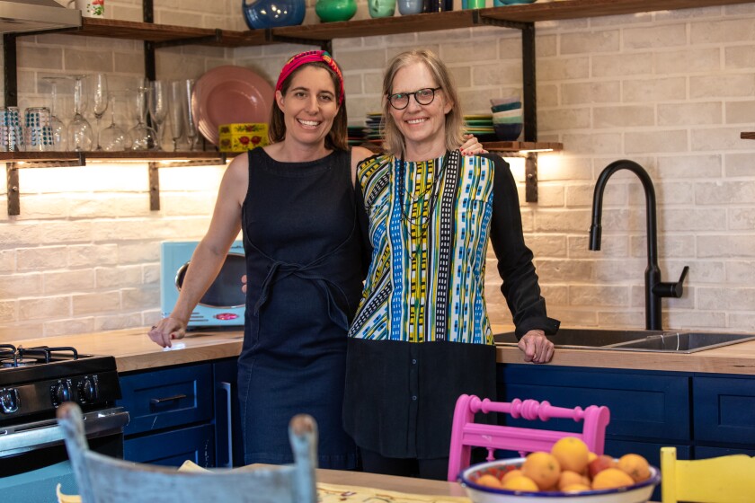 Caitlin Bigelow and her mother, Lynn O’Shaughnessy, pose in the new kitchen of O'Shaughnessy's converted garage apartment. 