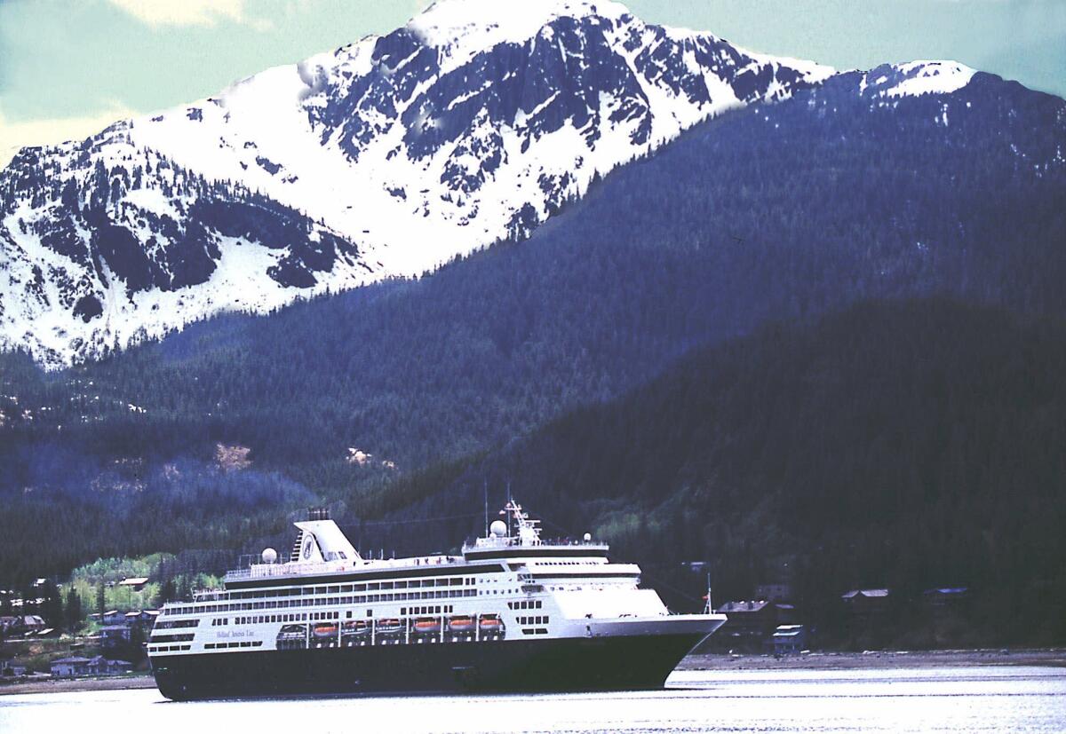 A Holland America Line cruise ship makes its way down Gastineau Channel as it leaves Juneau, Alaska.