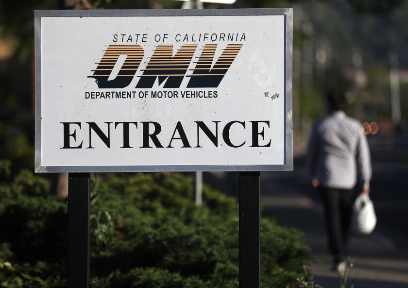 A sign is posted in front of a California Department of Motor Vehicles (DMV) office.