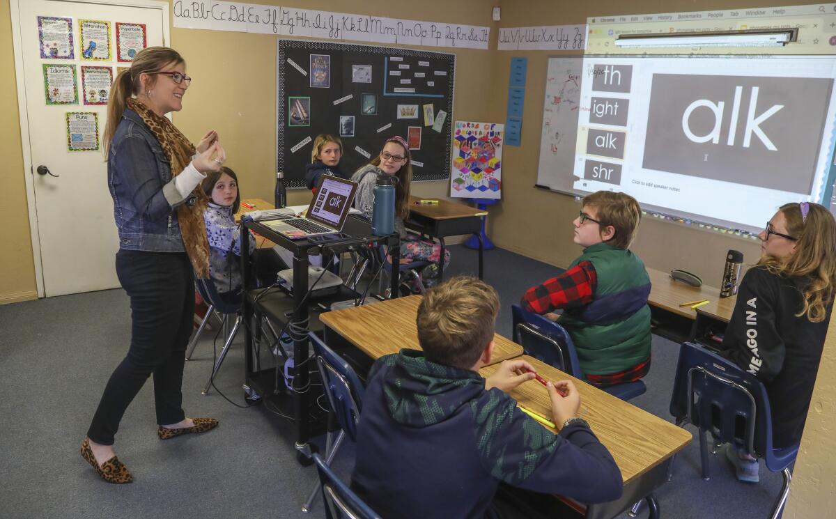 A teacher works with 6th and 7th graders on a phonics lesson in Poway, Calif., in January 2020. 