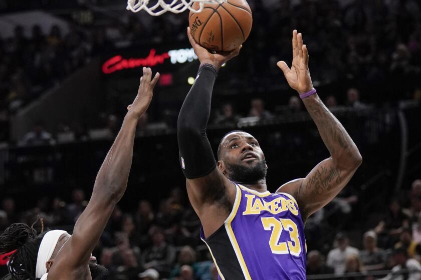 Los Angeles Lakers' LeBron James (23) shoots as he is defended by San Antonio Spurs' DeMarre Carroll during the first half of an NBA basketball game, Sunday, Nov. 3, 2019, in San Antonio. (AP Photo/Darren Abate)
