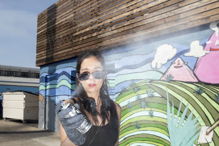 San Diego, CA - September 13: Paola "Panca" Villasenor, 35, stands in front of an unfinished mural called "Mi Tierra" outside of La Dona in Ocean Beach on Monday, Sept. 13, 2021 in San Diego, CA. The finished mural will be unveiled on Mexican Independence Day.(Ana Ramirez / The San Diego Union-Tribune)
