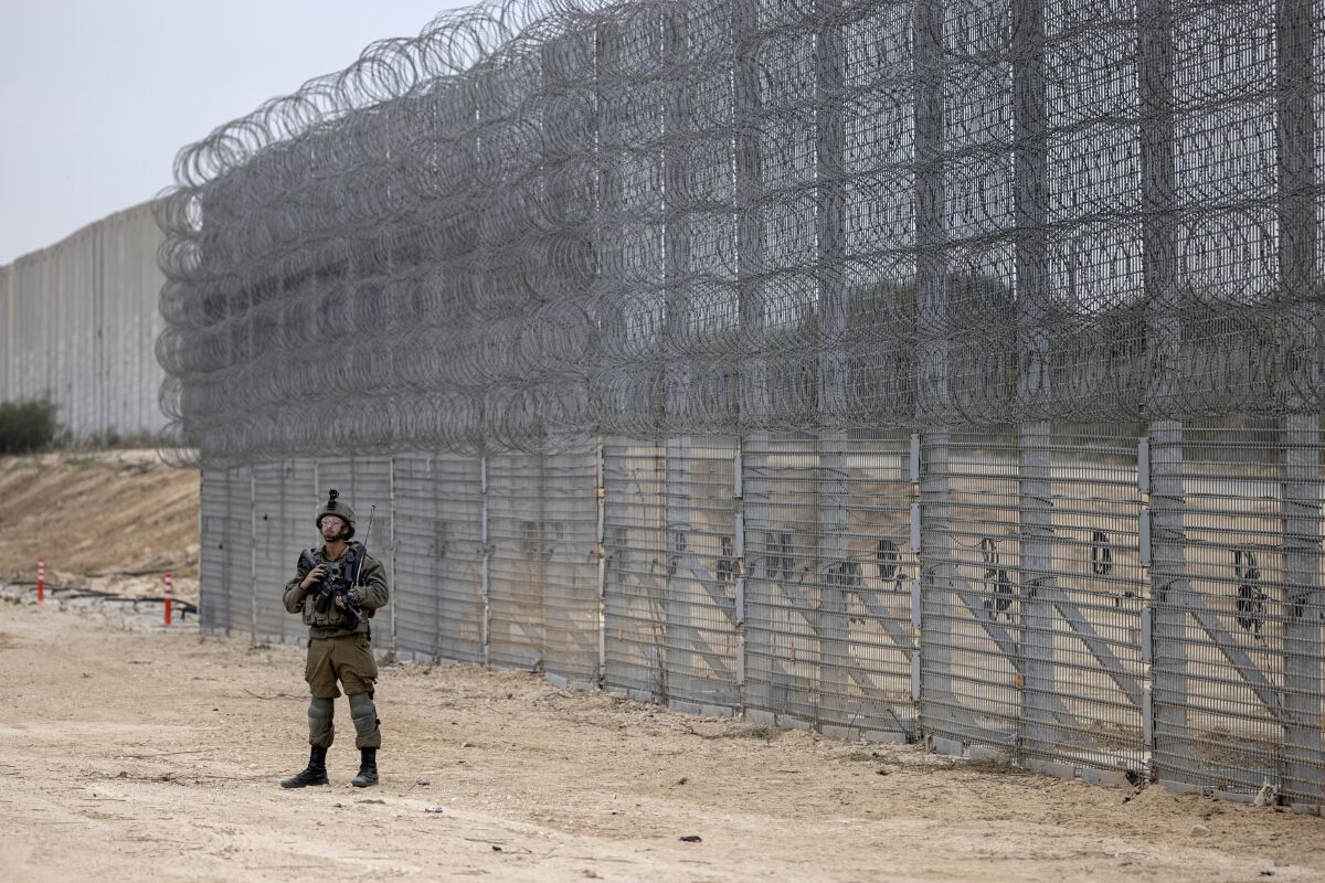 An Israeli soldier stands guard during a ceremony opening the newly completed underground barrier along the Israel-Gaza border, Tuesday, Dec. 7, 2021. Israel has announced the completion of the enhanced security barrier around the Gaza Strip designed to prevent militants from sneaking into the country. (AP Photo/Tsafrir Abayov)