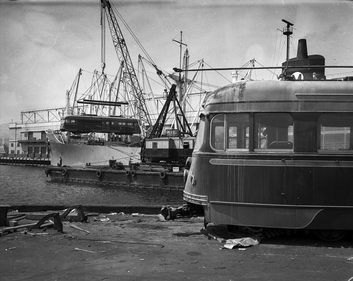 Sept. 6, 1959: A barge-mounted crane, left, loads a streetcar onto vessel.