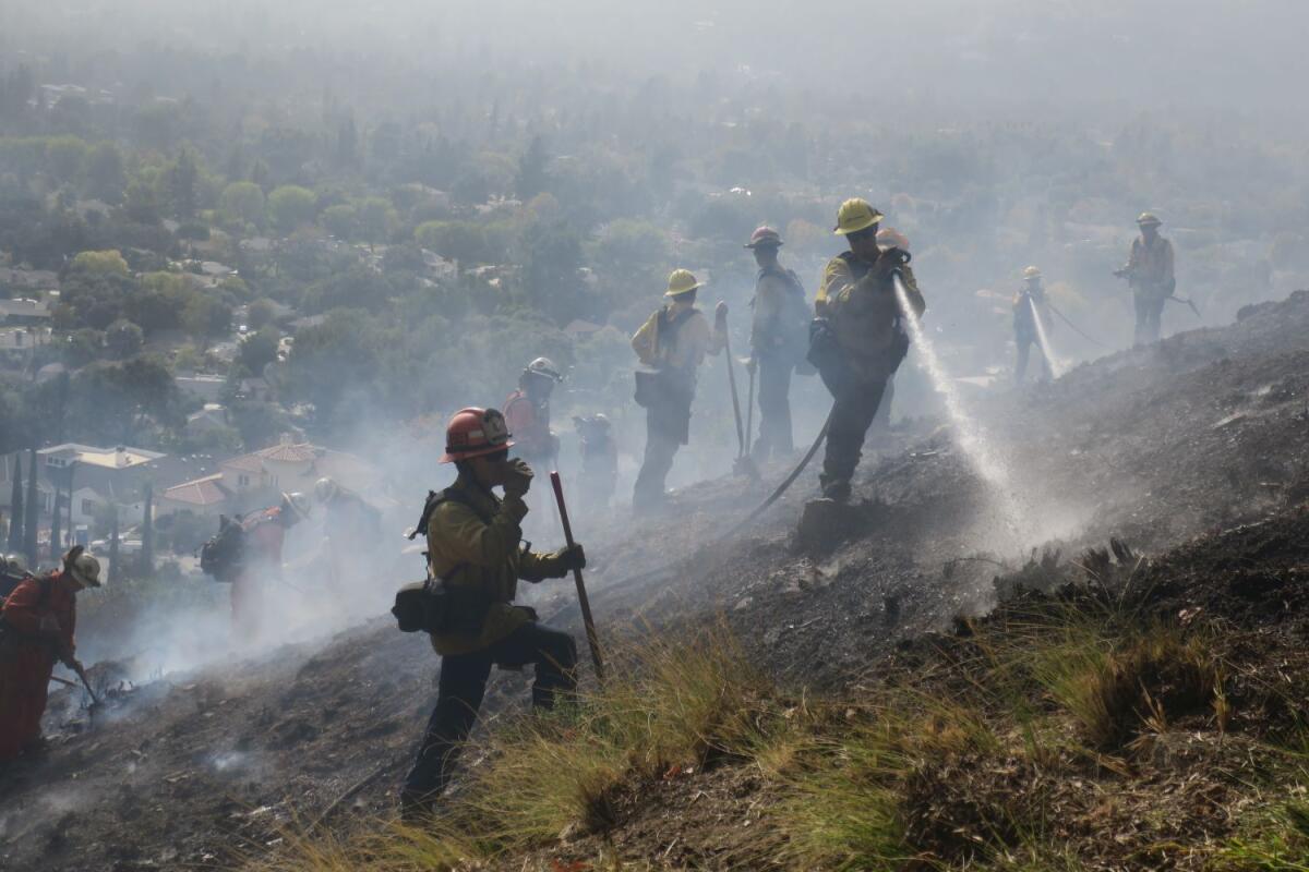 More than 100 firefighters responded to a blaze that broke out near the La Cañada Flintridge Country Club Thursday at around 11:45 a.m. Two super scoopers and water-dropping helicopters were used to douse small embers scattered throughout the hillside brush.