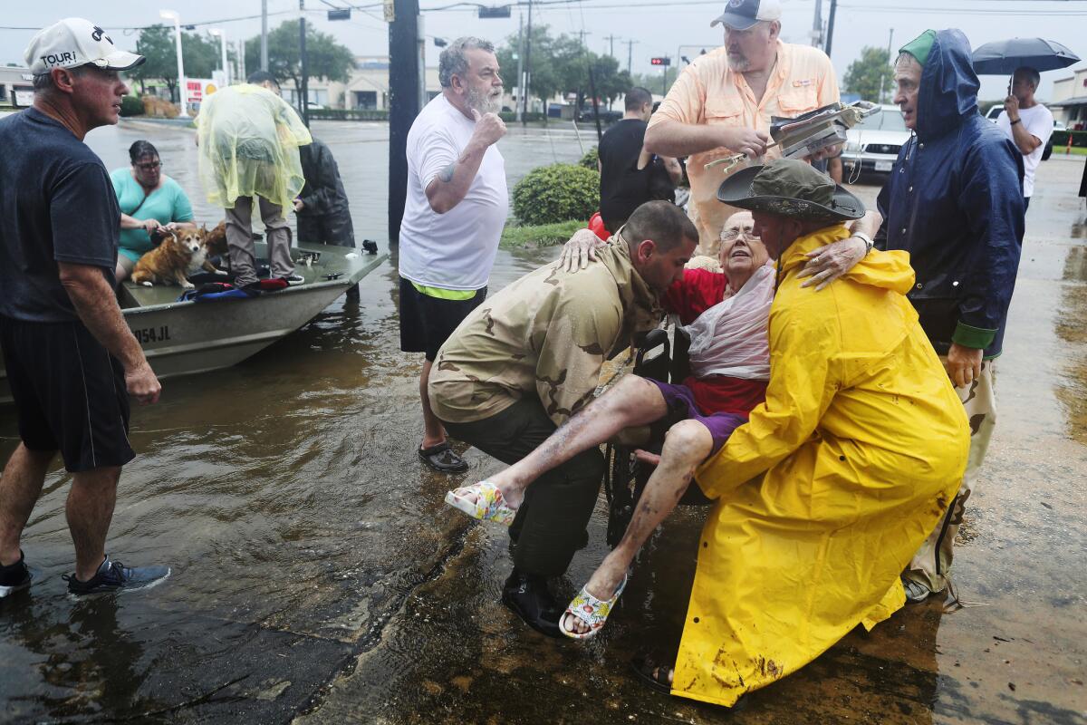 Neighbors rescue Jane Rhodes in Friendswood, Texas, on Sunday. (Steve Gonzales / Houston Chronicle )