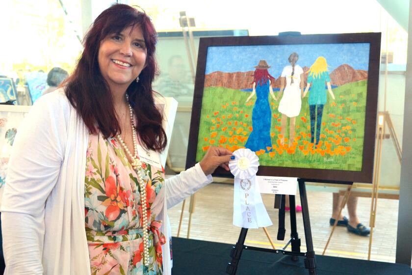 Susie Sprinkel Hudson stands with her third-place ribbon and "3 Women in a Field of Poppies."