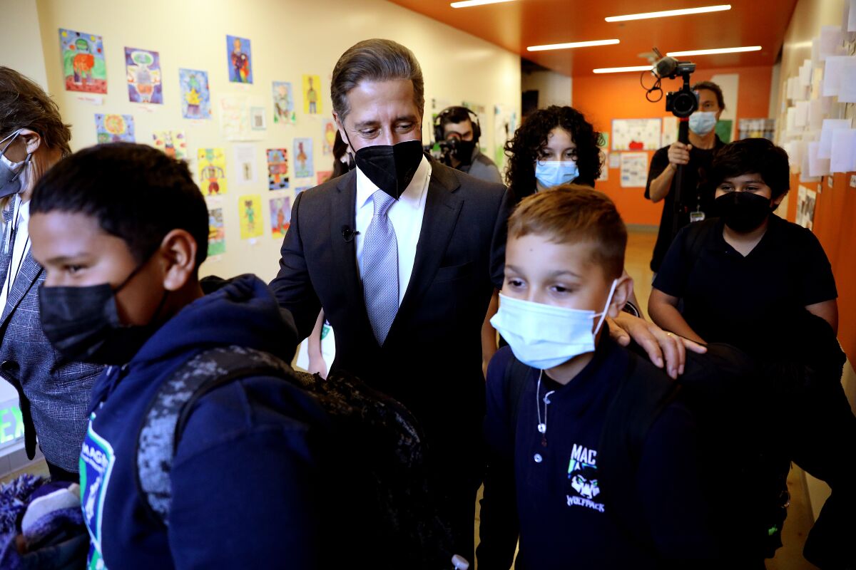 Alberto Carvalho walks with students wearing masks