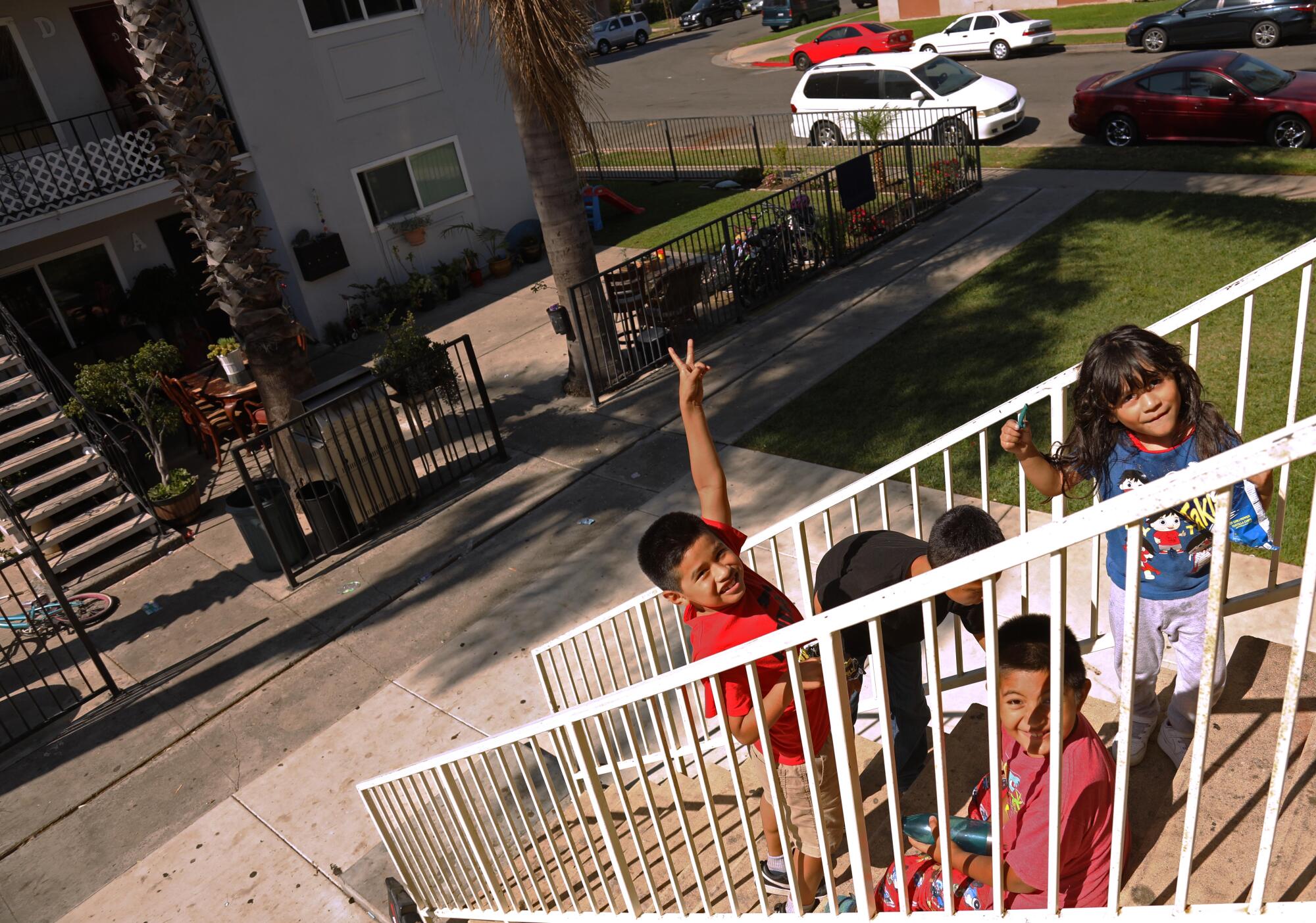 Children play on the staircase in front of their apartment in Oak View.