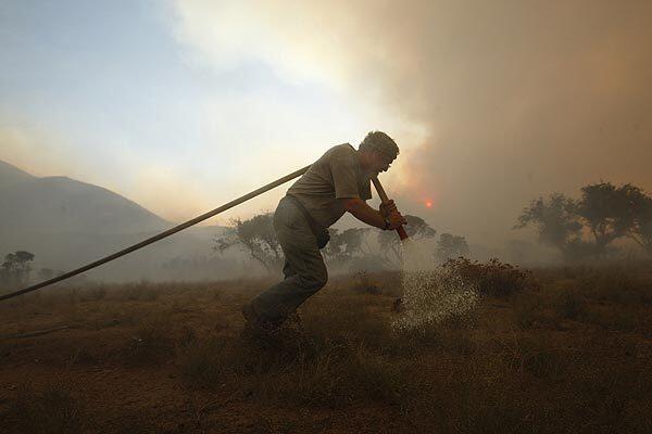 Ted Hamm stays behind to protect his mobile trailer home as the Station fire makes a pass to his property off Aliso Canyon Road in Acton. His home survived the flames. He's been living on the property for three years and hopes to build on it. "We bought it for the view. It's just not going to be as pretty," he said.