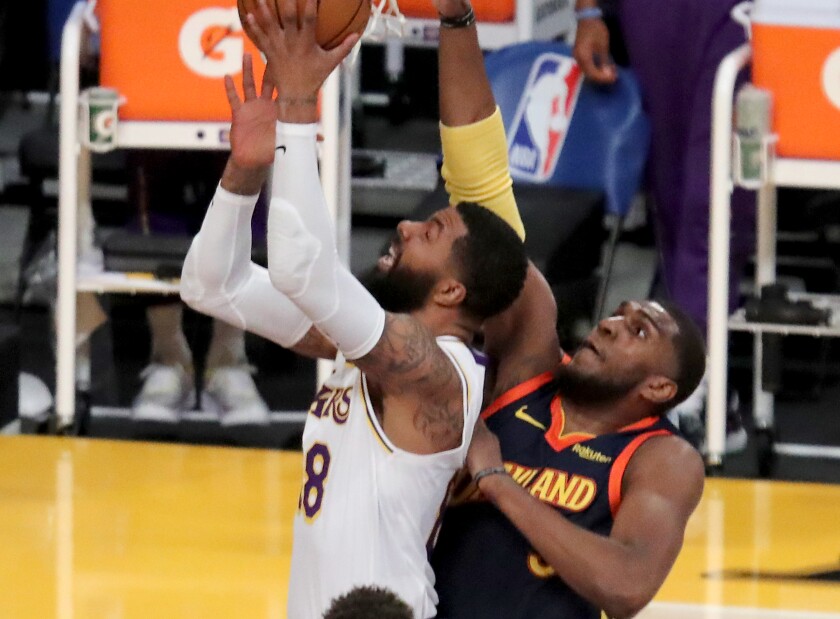 Lakers forward Markieff Morris drives to the basket in front of Golden State Warriors center Kevon Looney.