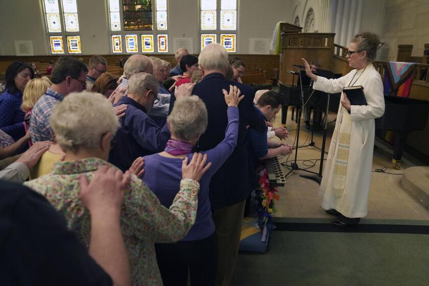 The Rev. Tracy Cox of First United Methodist Church and members of her congregation pray for Tracy Merrick, who will attend the United Methodist General Conference as a delegate representing Western Pennsylvania, as well as Anais Hussian and Joshua Popson who will also be in attendance, Sunday, April 14, 2024, in Pittsburgh. Hussian is a reserve delegate and Popson will be advocating for LGBTQ inclusion with the Love Your Neighbor Coalition. Many, including Rev. Cox, hope that this is the year they change longstanding bans on LGBTQ clergy and same-sex marriage. (AP Photo/Jessie Wardarski)