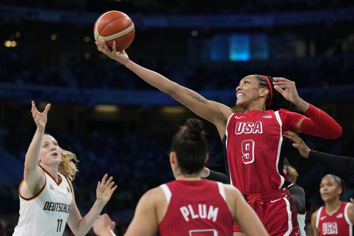 U.S. star A'ja Wilson grabs a rebound over Marie Guelich of Germany in a women's group play game Sunday.