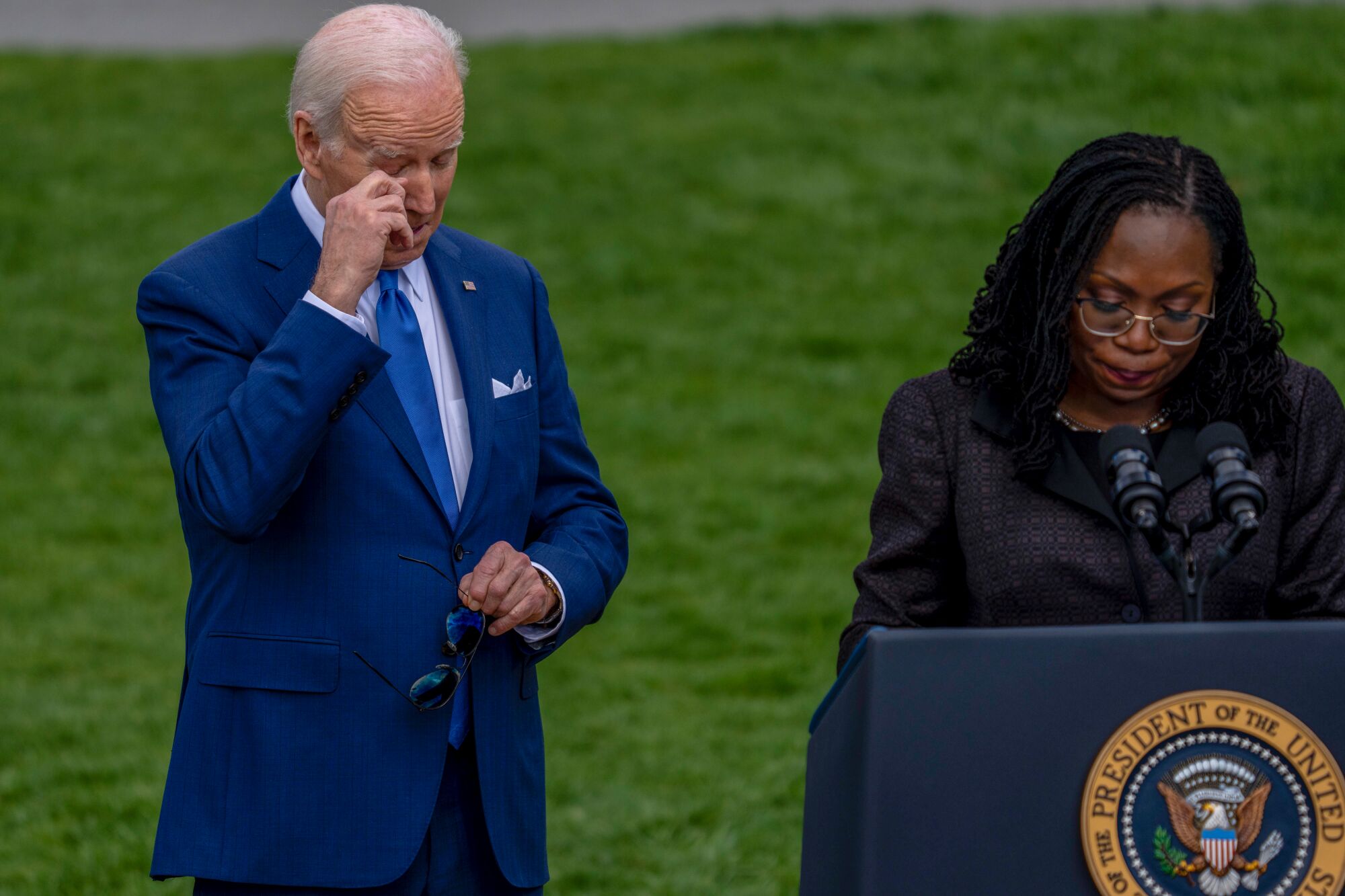 President Joe Biden wipes his eyes while Judge Ketanji Brown Jackson delivers remarks during an event on the South Lawn.