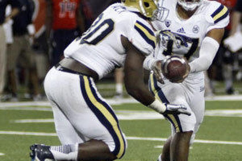 Myles Jack takes a handoff from UCLA quarterback Brett Hundley against Arizona.