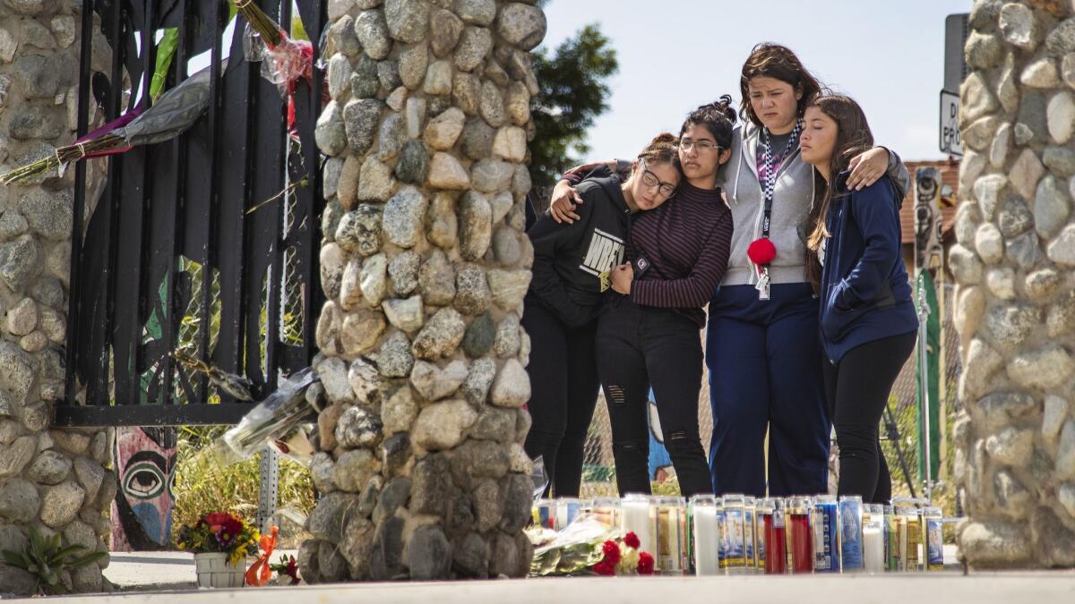 Students console each other at a memorial for slain South El Monte High School student Jeremy Sanchez, 17, near the San Gabriel River Trail.