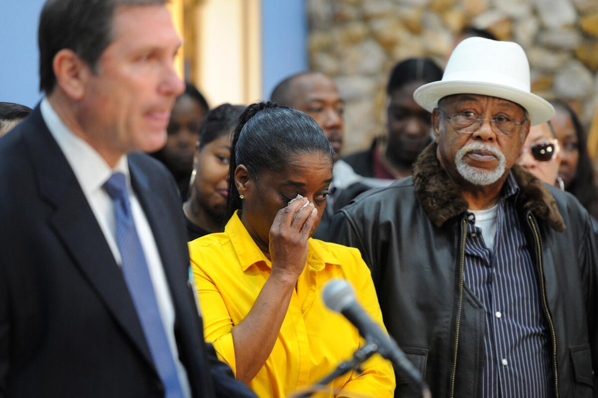 Gwendolyn Williams and Kirby Williams, parents of shooting victim Richard Williams, listen as Los Angeles County Sheriff's Lt. John Corina speaks at a news conference asking for the public's help in solving the May 2016 killings of their son and another man.