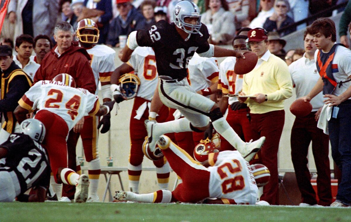 In this Jan. 22, 1984, file photo, Raiders running back Marcus Allen runs during Super Bowl XVIII against Washington.