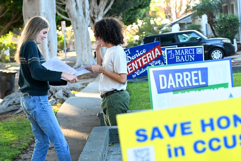 Culver City, California November 2, 2022-Culver City High School senior Ada Meighan-Thiel hands information to Adam Sondik for his parents to review on a measure that would allow the voting age to be lowered to 16-years-old. (Wally Skalij/Los Angeles Times)