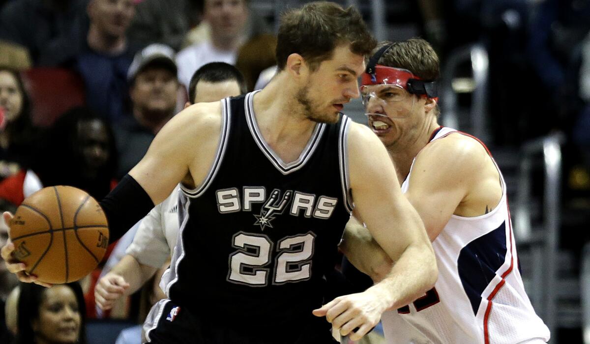 Spurs center Tiago Splitter works in the post against Hawks guard Kyle Korver in the third quarter Sunday night in Atlanta.