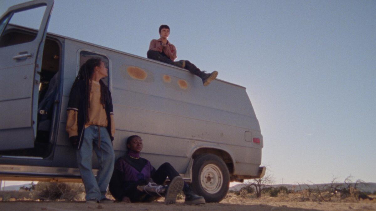 Three activists sitting around a rusty van