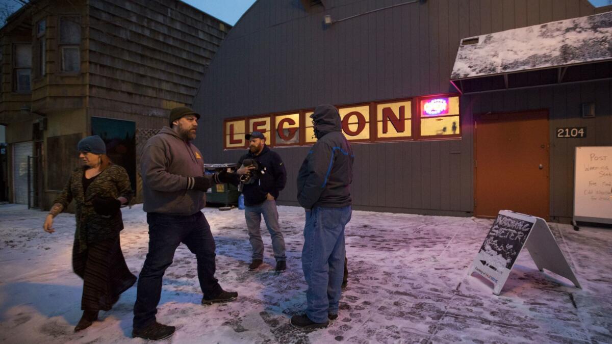 Sean Davis, second from left, commander of American Legion Post 134 in Portland, Ore., coordinates with other veterans to open the facility as a shelter during a recent cold spell.