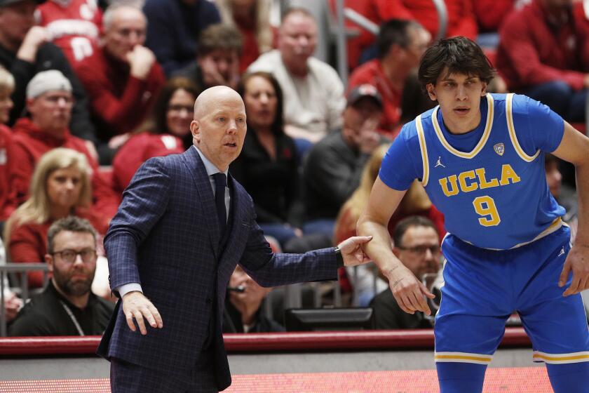 UCLA head coach Mick Cronin, left, speaks with forward Berke Buyuktuncel (9) during the first half of an NCAA college basketball game against Washington State, Saturday, March 2, 2024, in Pullman, Wash. (AP Photo/Young Kwak)