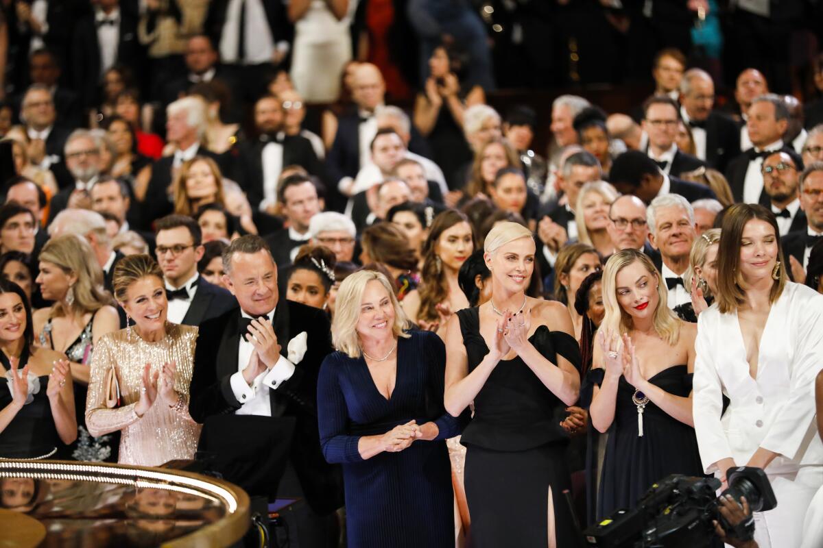 The audience including Rita Wilson, Tom Hanks and Charlize Theron reacts as Renée Zellweger, winner of the lead actress Oscar for “Judy” walks to accept her award as seen from backstage at the 92nd Academy Awards.