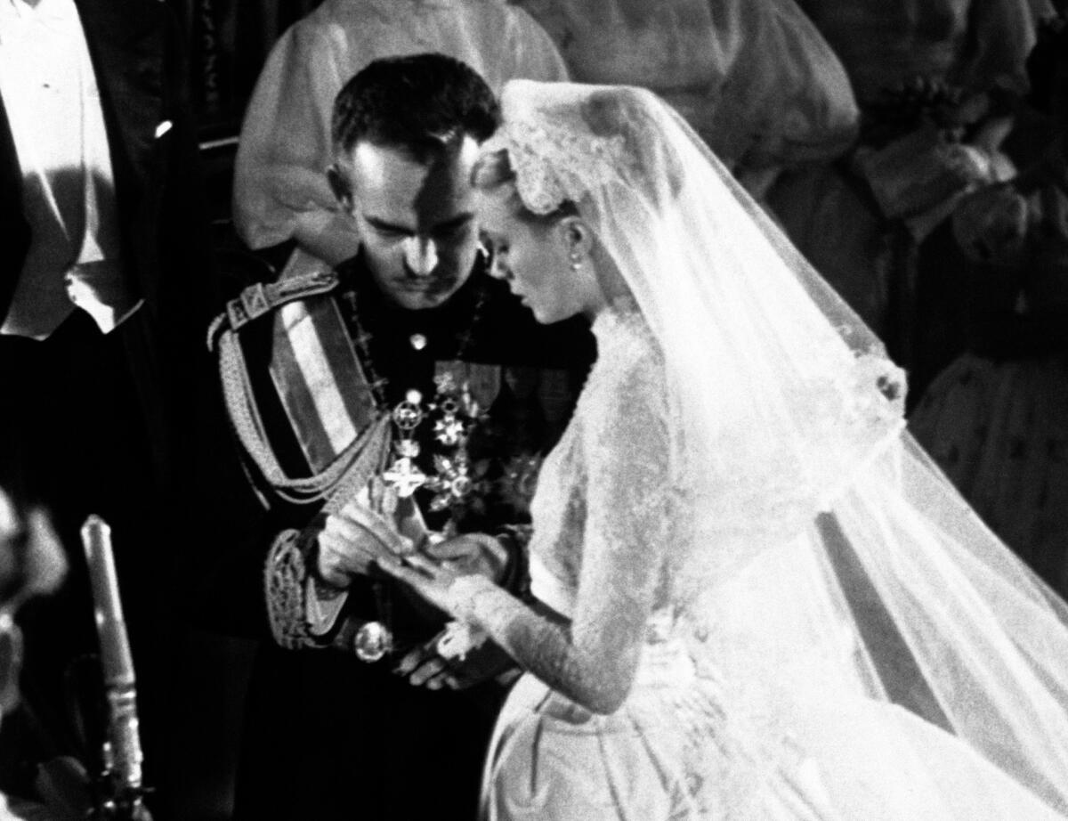 En esta foto del 19 de abril de 1956, el príncipe Rainier le coloca el anillo en el dedo a Grace Kelly durante la ceremonia de su boda, en Mónaco. Kelly dejó la actuación a los 26 años para convertirse en princesa, asentándose en el pequeño y acaudalado principado mediterráneo en la Riviera. (AP Foto, Archivo)